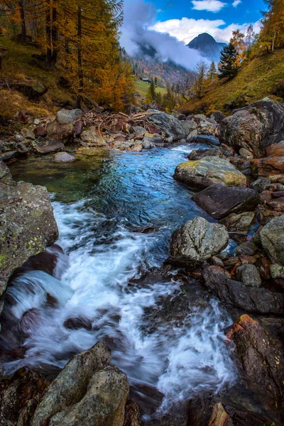 Paesaggio autunnale sulle montagne alpine con un fiume che scorre — Foto Stock