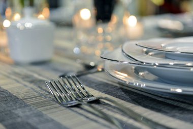 Boş beyaz tabak ve çatal bıçak takımları üzerinde boş misafir kartı olan masa ayarları, boşluğu kopyala.