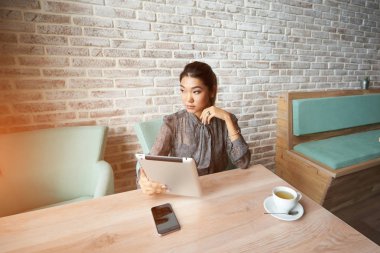 Kadın yatırımcı dokunmatik yüzey üzerinden İnternet finans haberleri okuyor