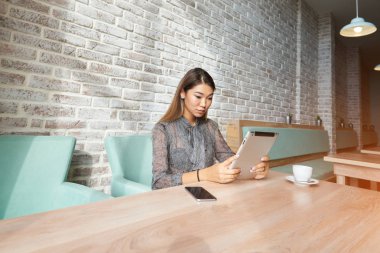 Kadın yatırımcı dokunmatik yüzey üzerinden İnternet finans haberleri okuyor