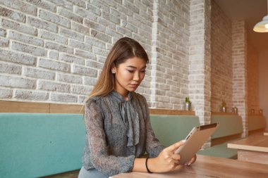Kadın yatırımcı dokunmatik yüzey üzerinden İnternet finans haberleri okuyor