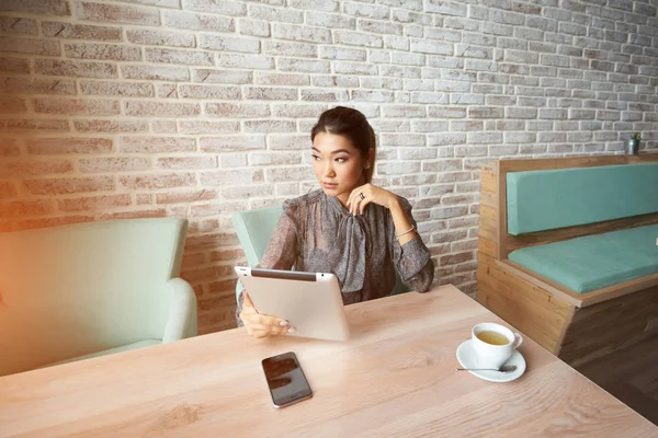 Vrouwelijke financier is het lezen van financiële nieuws op internet via touchpad — Stockfoto