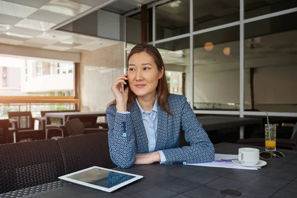 Mujer de negocios kazaja llamando con teléfono celular Imagen De Stock