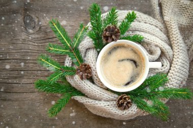 kahve ahşap bir masa üzerinde duruyor. rahat sıcak örme şal,