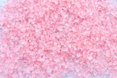 Büyük, pembe deniz tuzu kristalleri serpiştirilmiş mavi bir arka plan üzerinde metin için yer alan bir yığın. vücut bakımı kavramı.