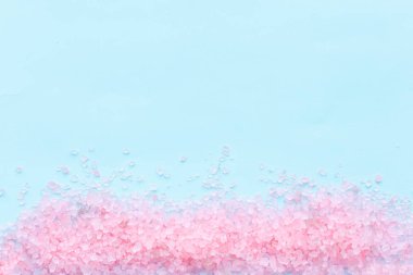 Büyük, pembe deniz tuzu kristalleri serpiştirilmiş mavi bir arka plan üzerinde metin için yer alan bir yığın. vücut bakımı kavramı.