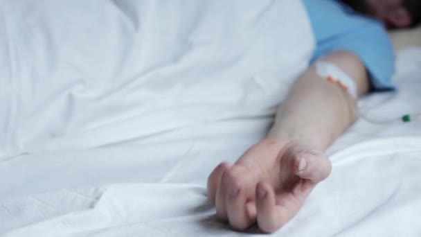 Todkranke kaukasische männliche Patienten mit Krämpfen in der Hand, Tropfer im Arm, Person mit Schmerzen im Krankenhausbett — Stockvideo