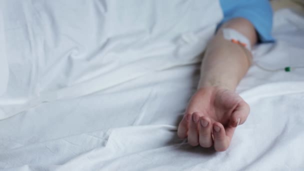 Caucasian man in a hospital bed trying to move his fingers. emotional moment. — Stock Video