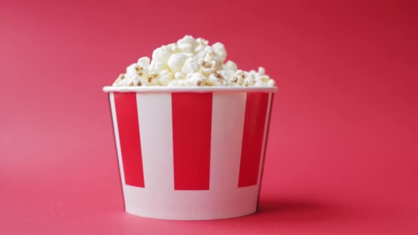 Childrens Caucasian hand taking popcorn from striped red and white paper box — Stock Video