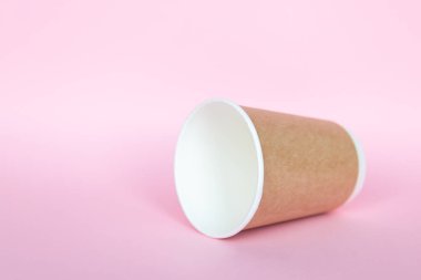 Pembe arka planda tek kullanımlık çevresel kağıt çatallarıyla ayarlandı