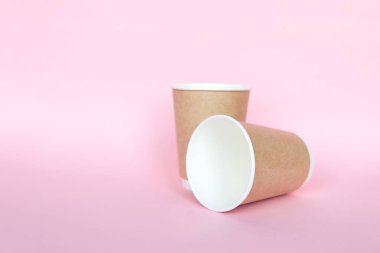 Pembe arka planda tek kullanımlık çevresel kağıt çatallarıyla ayarlandı