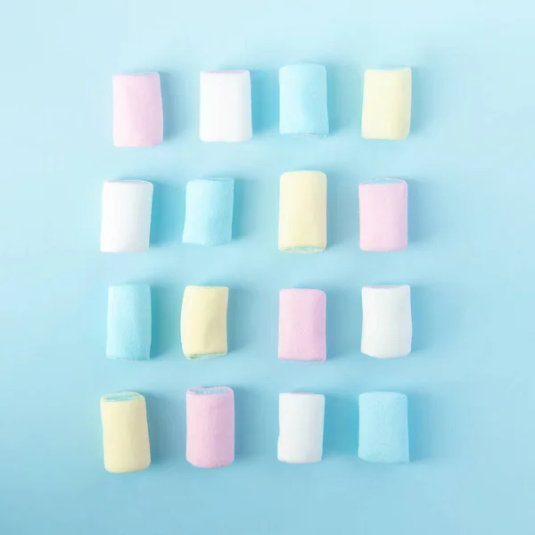 Brillanti marshmallow multicolori su sfondo blu — Foto Stock