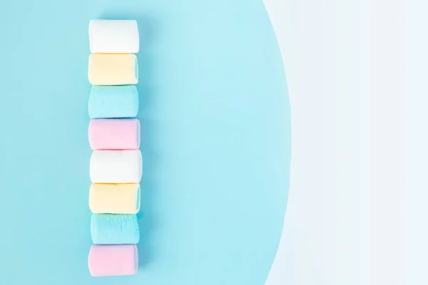 Brillanti marshmallow multicolori su sfondo blu — Foto Stock