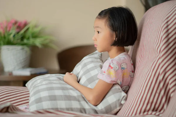 Asian child (girl) at home during Covid-19 RMO (restricted movement order) lockdown, watching TV