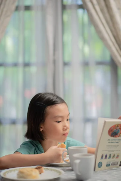 Azji Chińskie Dziecko Czytanie Książki Podczas Śniadania — Zdjęcie stockowe