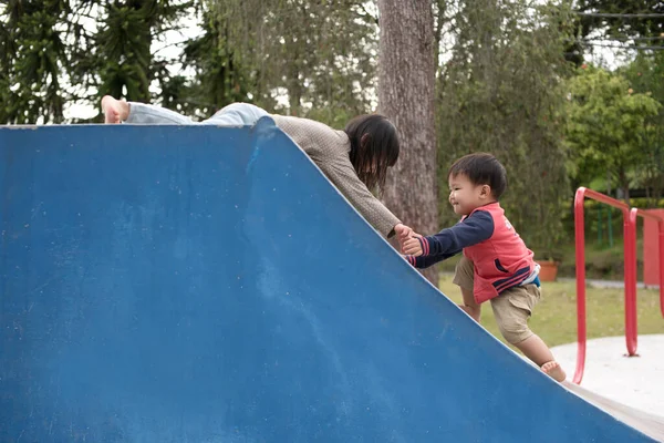 Older Asian Child Helping Younger Child Ramp While Playing Playground — Stock Photo, Image