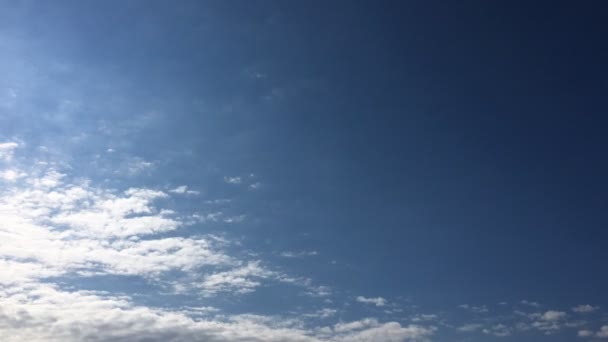 Білі хмари зникають на гарячому сонці на блакитному небі. Хмари руху, що перетинаються у часі, синій фон неба . — стокове відео