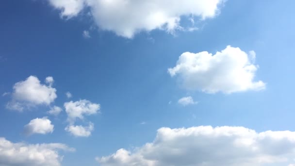 Beyaz bulutlar güneşin altında mavi gökyüzü üzerinde kaybolur. Hızlandırılmış hareket bulutlar mavi gökyüzü arka plan. — Stok video
