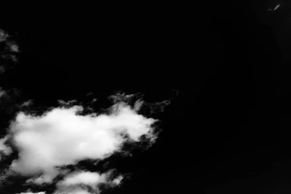 Geïsoleerde wolken boven zwart. — Stockfoto