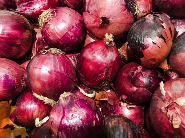 Piyasada birçok büyük arka plan kırmızı soğan arasında taze organik kırmızı soğan göze çarpıyor. Kırmızı soğan kök yığını.