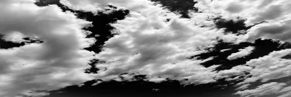 Vereinzelt weiße Wolken am schwarzen Himmel — Stockfoto