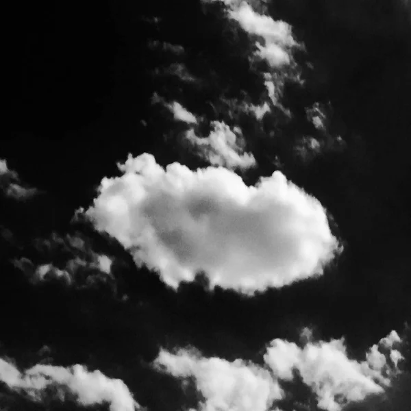 Isolated white clouds on black sky