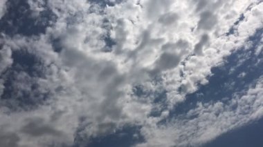 Beyaz bulutlar güneşin altında mavi gökyüzü üzerinde kaybolur. Hızlandırılmış hareket bulutlar mavi gökyüzü arka plan.
