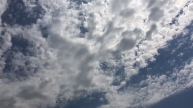 Beyaz bulutlar güneşin altında mavi gökyüzü üzerinde kaybolur. Hızlandırılmış hareket bulutlar mavi gökyüzü arka plan.