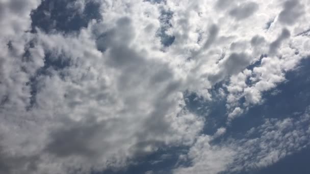 Белые облака исчезают в жарком солнце на голубом небе. Временные облака голубого неба . — стоковое видео