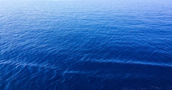 Textura del agua en la costa mediterránea del mar. guijarros en la playa. Textura de la orilla del mar. El mar Adriático . — Foto de Stock