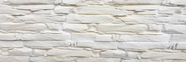 White painted stone wall texture as background. Cracked concrete vintage block stone wall background, old painted wall. Background wall painting.