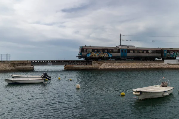 Faro tren istasyonundan ayrılan ve Faro, Algarve, Portekiz limanında kısa bir köprü geçen bir tren.. 