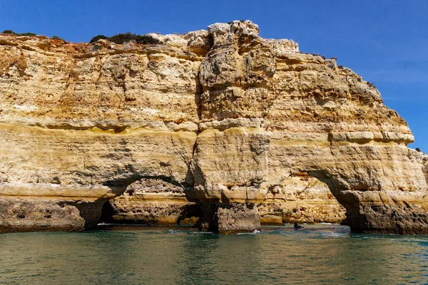 Kıyı şeridi boyunca uzanan kaya oluşumlarında kemerler, Algarve, Portekiz.