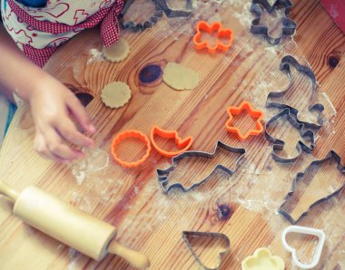 Evde bir çocuk kurabiye kesicileri kesiyor..