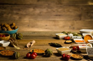 Çeşitli renkli baharat ve otlar rustik ahşap arka plan üzerinde. logo için yer