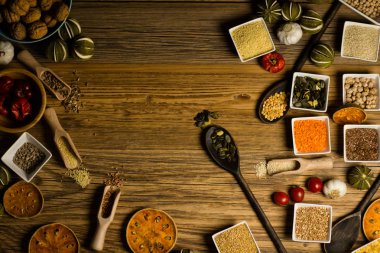 Çeşitli renkli baharat ve otlar rustik ahşap arka plan üzerinde. logo için yer