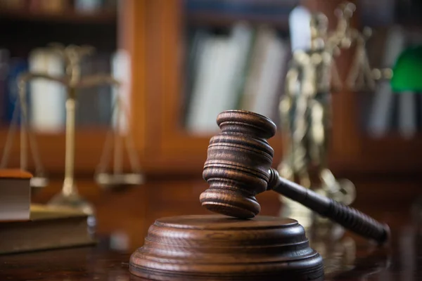 Judges mallet with justice scales and books on wooden rustic table, place for typography