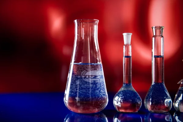 Attrezzature di laboratorio, un sacco di vetro pieno di liquidi colorati — Foto Stock
