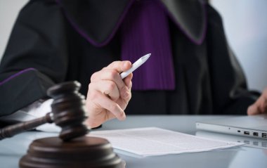 Adalet ve hukuk kavramı. Erkek yargıç mahkeme tokmak ve kitap ile çalışma