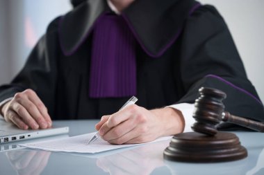 Adalet ve hukuk kavramı. Erkek yargıç mahkeme tokmak ve kitap ile çalışma