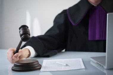 Adalet ve hukuk kavramı. Erkek yargıç mahkeme tokmak ve kitap ile çalışma