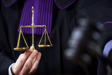 Erkek yargıç mahkeme salonunda tokmağa vuruyor.