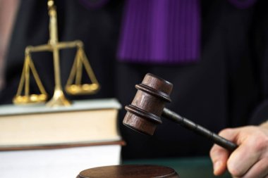 Erkek yargıç mahkeme salonunda tokmağa vuruyor.