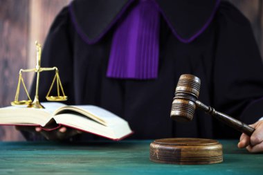 Erkek yargıç mahkeme salonunda tokmağa vuruyor.