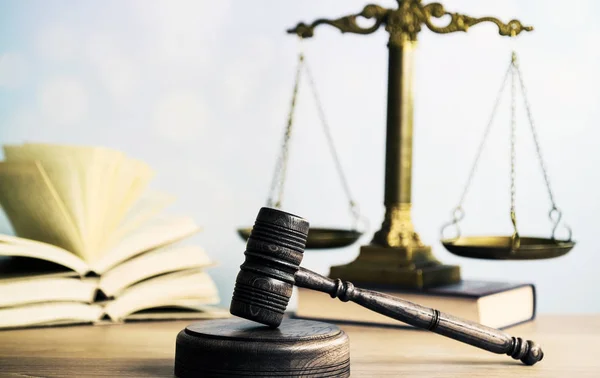 Concepto de ley: libro de leyes abierto con un mazo de jueces de madera sobre la mesa en una sala de tribunal o en una oficina de aplicación de la ley sobre fondo azul. Copiar espacio para texto — Foto de Stock