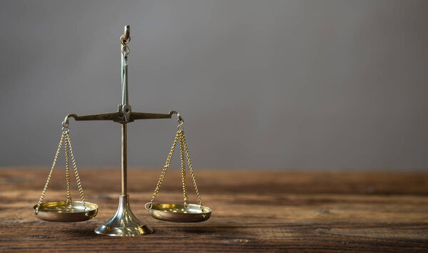 Концепция права - Открытая книга законов с деревянными судьями, молотком на столе в зале суда или в офисе правоохранительных органов на синем фоне. Копирование текста
