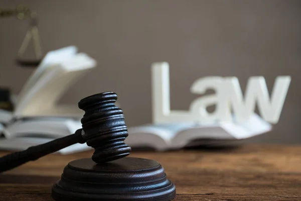 Law concept - Open law book with a wooden judges gavel on table in a courtroom or law enforcement office on blue background. Copy space for text — Stock Photo, Image