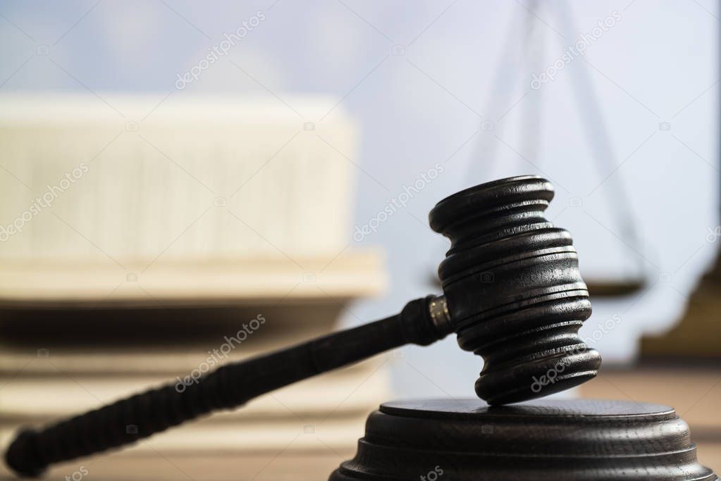 Law concept - Open law book with a wooden judges gavel on table in a courtroom or law enforcement office on blue background. Copy space for text