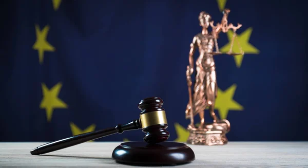 Law concept Gavel and Lady of Justice on wooden table, EU flag