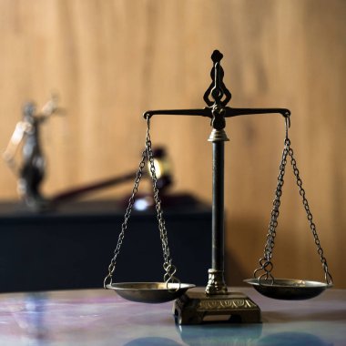 Hukuk ve Adalet 'in sembolü hâlâ hayattadır. Masa arkasındaki teraziler..